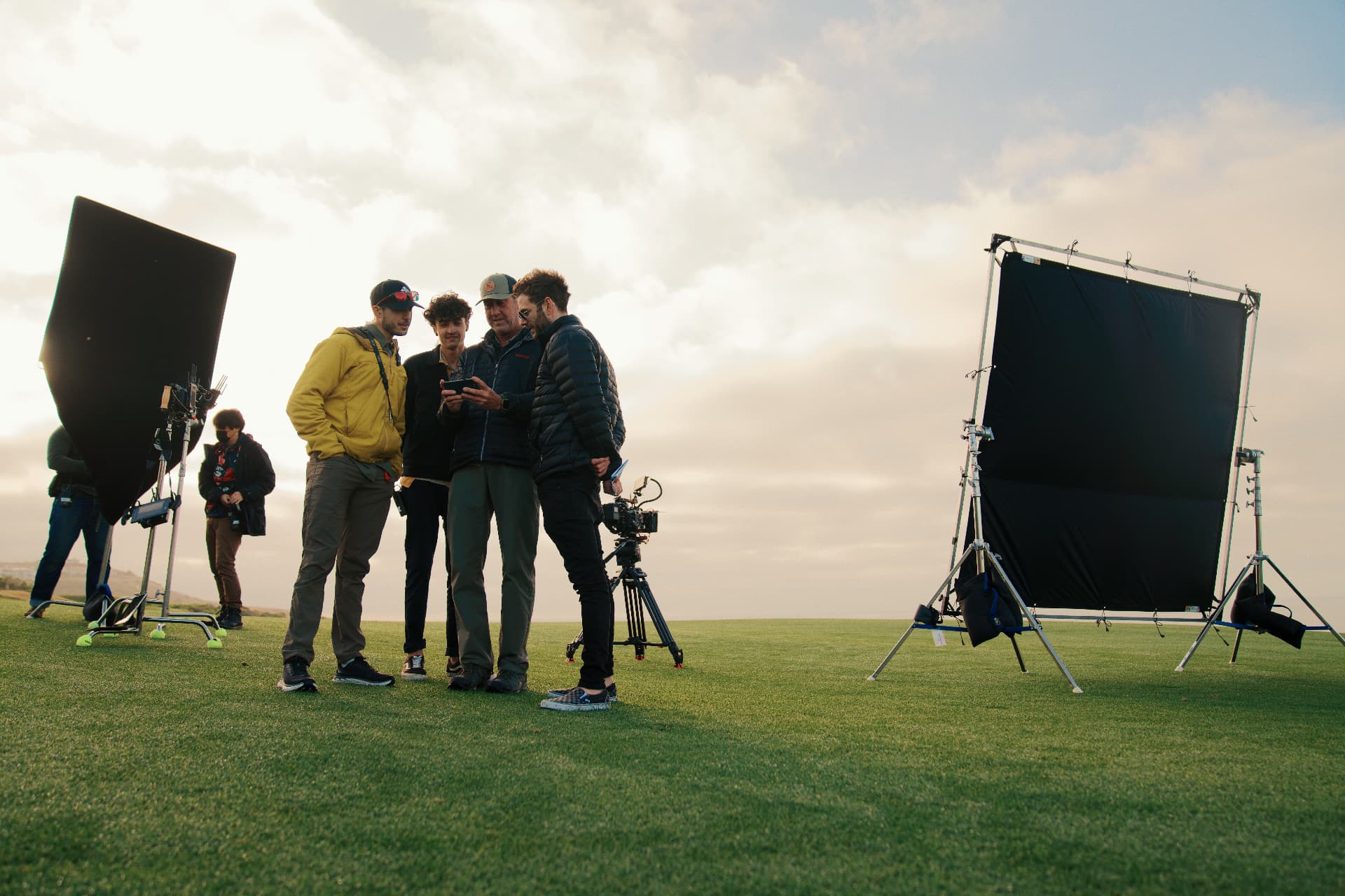 Crew gathered around a monitor at golden hour on the FILA Golf shoot.
