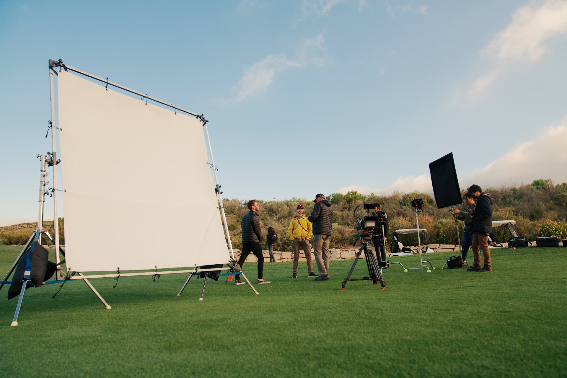 Crew setting a large diffusion frame on a coastal golf course for FILA Golf.