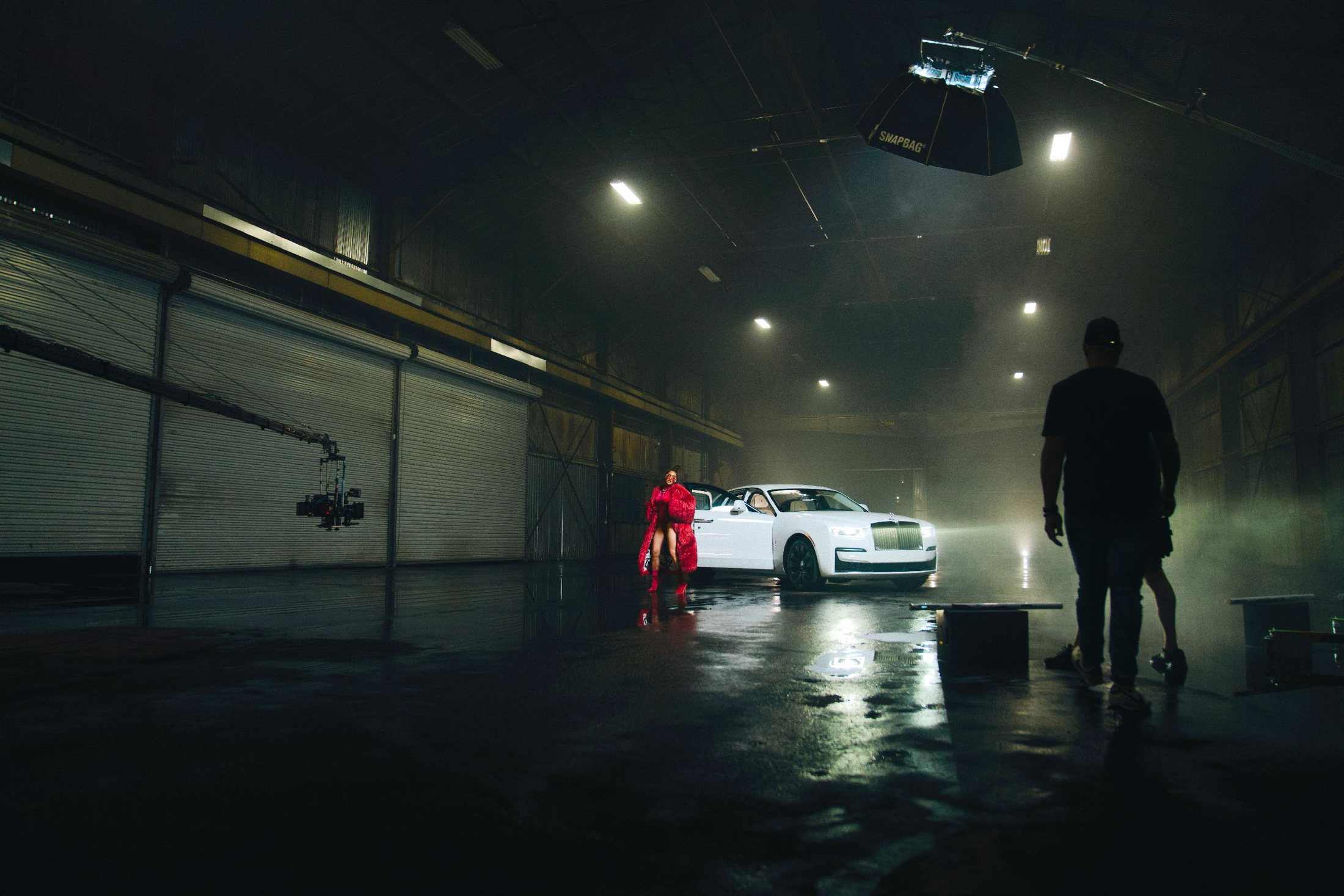 Wide behind-the-scenes frame of a night set with a car and crew.