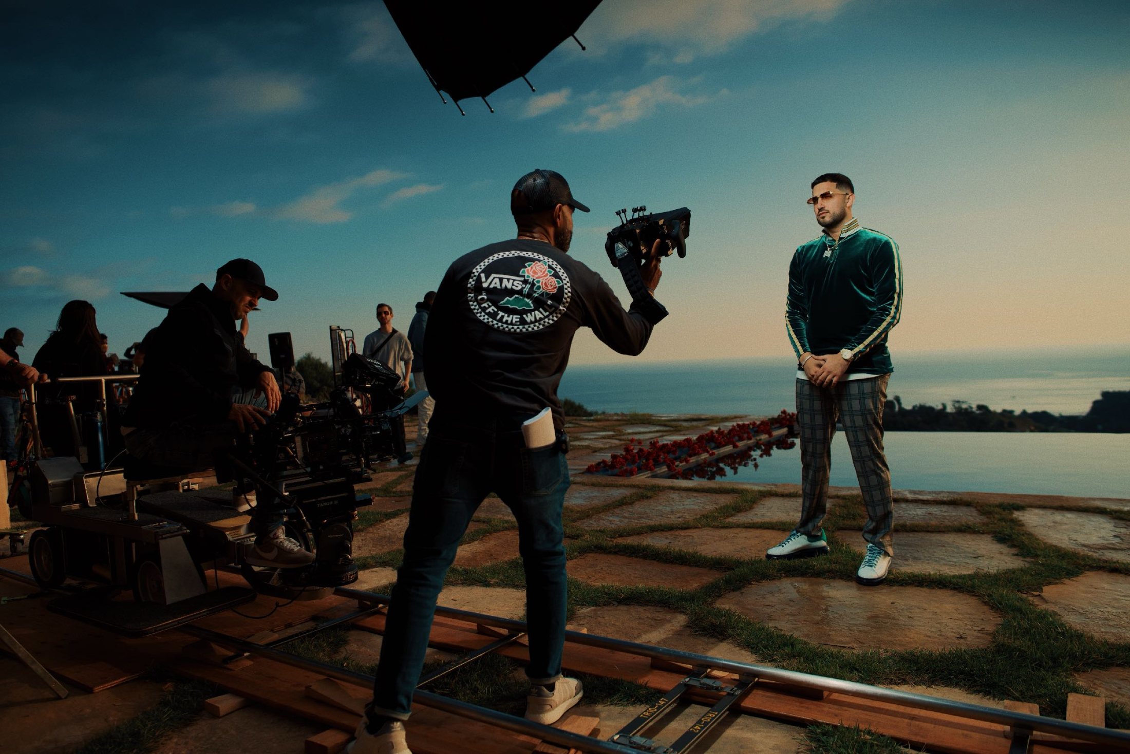 Camera crew shooting on dolly track beside the water.