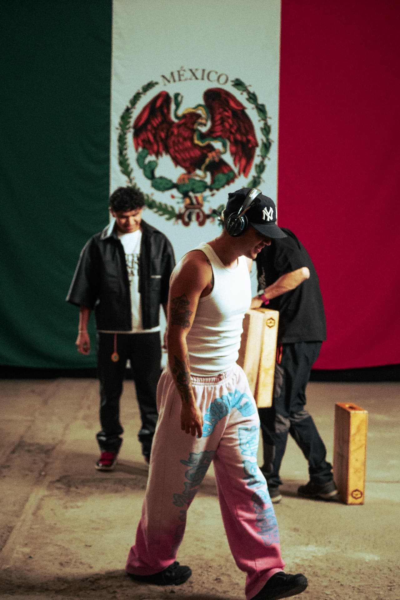 Artist walking on the Reloxito set in front of a Mexican flag backdrop.