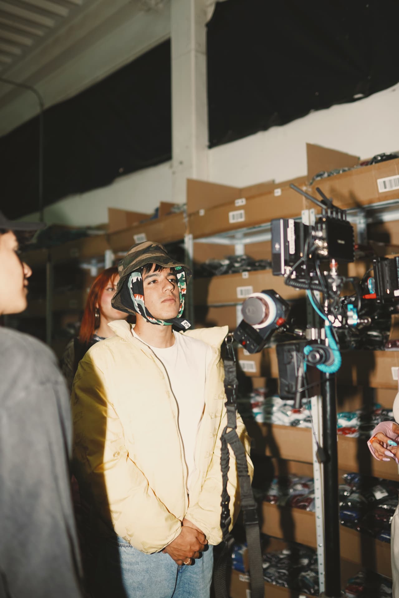 Marlon V beside camera on a warehouse set.