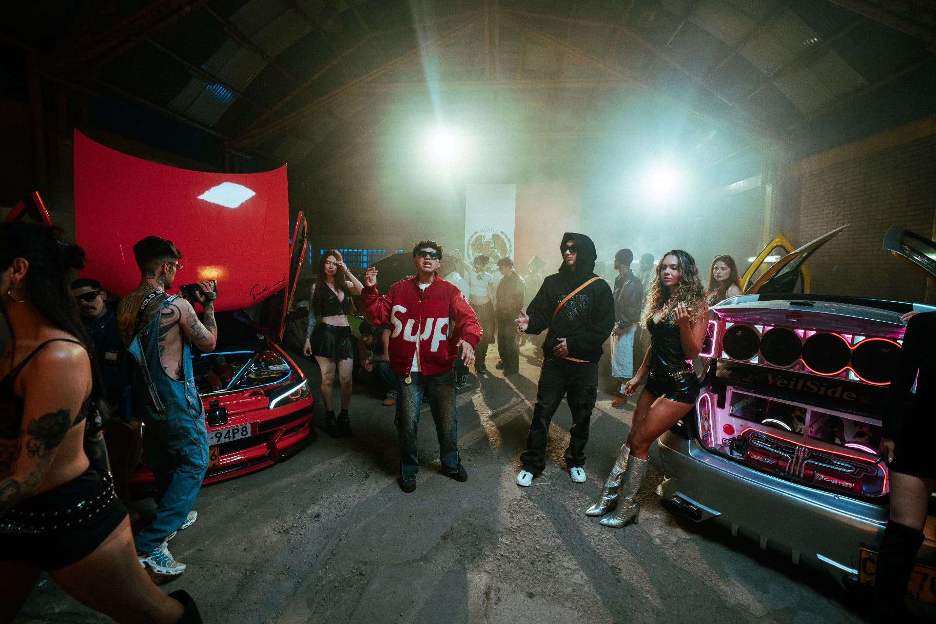 Cast performing between tuned cars on the Reloxito set.